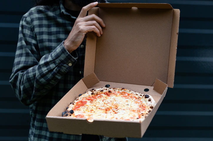 A man holding a pizza box