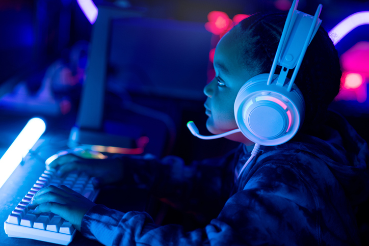 African child boy wear headphone excited playing video game