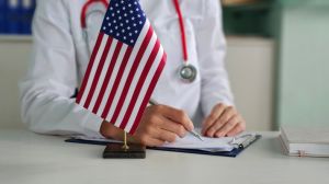 Doctor writes notes and American flag. Medicine in America concept