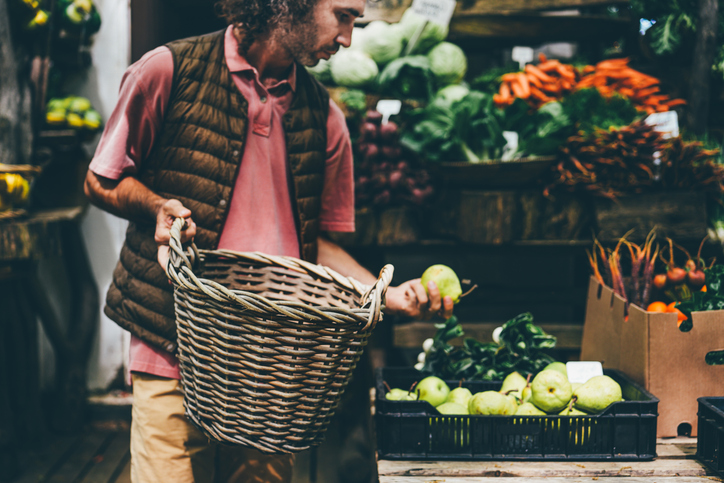 Men choosing fruits and vegetables at farmers market.