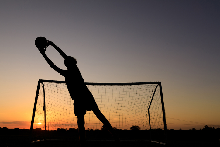 Boy Practicing Soccer Skills At Sunset