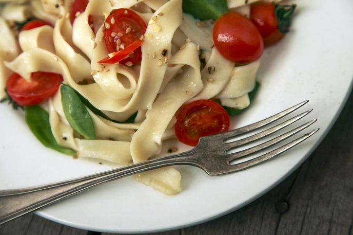 Delicious pasta dish with cherry tomatoes and fresh greens